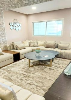 a living room filled with furniture and a large rug on top of a wooden floor