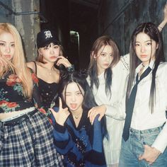 group of young women posing in an alleyway with one holding her hand up to the side