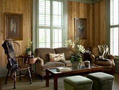 a living room filled with furniture and wooden walls