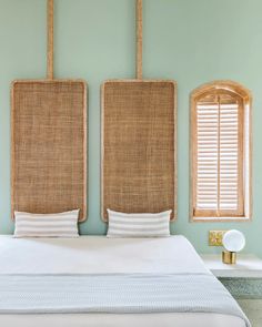 a bed with two wicker headboards on each side and white sheets in the middle