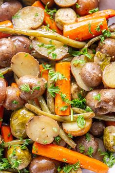 potatoes, carrots and other veggies are mixed together in a white bowl