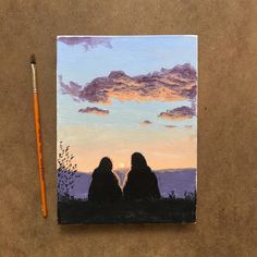 two people sitting on a hill with the sun setting in the background and a pencil resting next to them