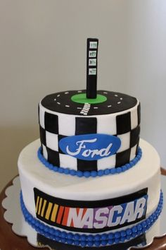 a three tiered cake is decorated with the nascar logo and ford's emblem