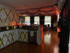 a kitchen decorated for halloween with lights and decorations on the walls, along with white cabinets