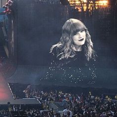 a large screen with a photo of taylor swift on it in front of a crowd