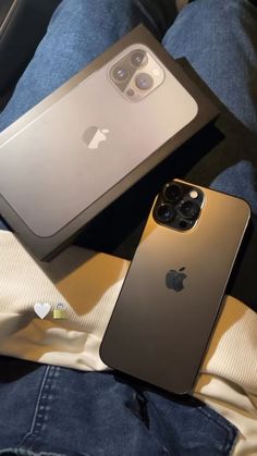 two iphones sitting next to each other on top of a person's lap