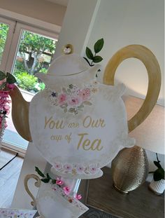 there is a teapot with flowers on it and the words you are our cup of tea