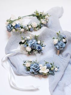 three blue and white flower hair combs on top of a cloth covered tablecloth