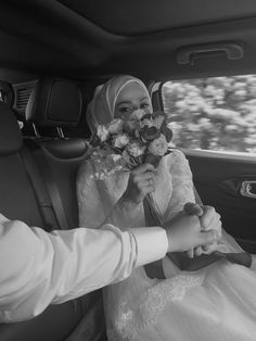 a bride and groom in the back seat of a car holding hands with each other