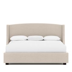 an upholstered bed with white pillows and sheets on it, in front of a white background