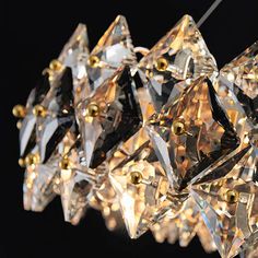 a chandelier made out of crystal cubes with gold accents on the sides