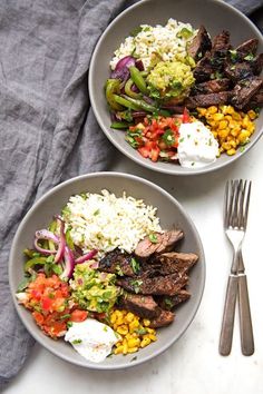 two bowls filled with meat, rice and veggies on top of a table