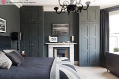 a bedroom with gray walls and black furniture