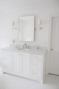 a white bathroom with double sinks and mirrors