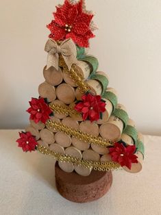 a wine cork christmas tree with poinsettis and bells on it's top