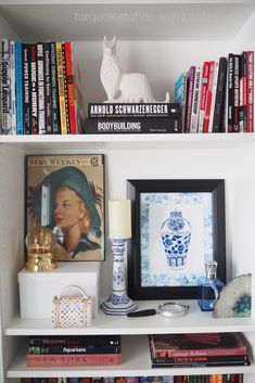 a white book shelf with books and pictures on it