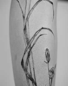 a black and white photo of a flower on the thigh