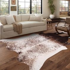 a living room filled with furniture and lots of window sills on top of hard wood flooring