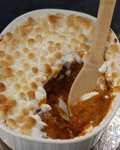 a bowl filled with marshmallows and a wooden spoon