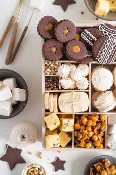 a wooden box filled with lots of different types of cookies and desserts on top of a table