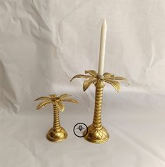 two golden candlesticks with palm trees on them