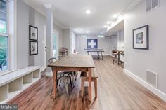 a large open floor plan with wood floors and white walls, along with built - in shelving