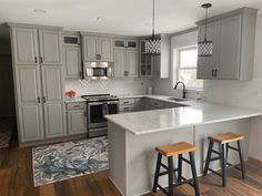 a kitchen with two stools in front of an island and cabinets on the other side