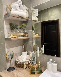 the bathroom is decorated in neutral colors and features shelves with towels, soaps and other decorative items