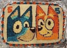 a birthday cake decorated with the number four and two dogs on it's sides