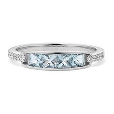 a white gold ring with three princess cut diamonds