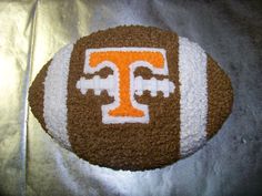 a cake shaped like a football with the letter t on it's center piece