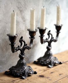 three candelabra candles are sitting on a wooden table