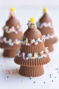 three chocolate christmas trees with sprinkles and stars on top, sitting next to each other