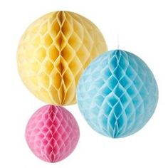 three honeycombs hanging from the ceiling in pastel blue, yellow and pink