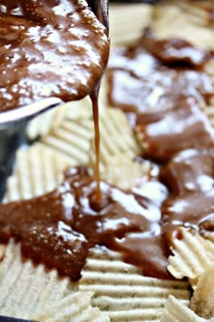 someone is pouring chocolate sauce on top of some waffles in a baking pan