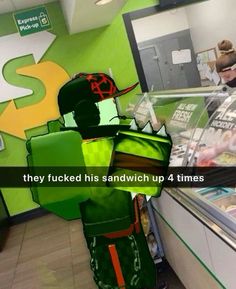 a man in a green costume standing next to a display case