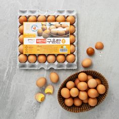 an egg carton filled with brown eggs next to a basket of sliced oranges