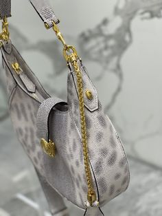 With its unique shape, iconic details and versatile charm, it adds a fashionable atmosphere to the world of SERPENTI FOREVER.
This everyday bag is crafted from silver-pink calfskin with a cowhide center and snake-print blue scales on both sides. It is paired with gold-plated brass accessories. The charming classic snake head is embellished with silver scales and pink enamel eyes in the center. The front magnetic buckle is hidden Under it.
Featuring a single compartment, adjustable chain and leather shoulder strap and removable leather handle, it can be worn cross-body or as a classic shoulder bag. Practical top zip with an internal pocket, an external pocket on the back and BVLGARI metal logo.

Dimensions: 25.5×25×5.5 cm High-end Silver Shoulder Bag With Palladium Hardware, Luxury Silver Bag With Chain Strap, Luxury Silver Bags With Chain Strap, Luxury Silver Shoulder Bag With Chain Strap, Luxury Silver Shoulder Bag With Palladium Hardware, High-end Silver Leather Shoulder Bag, Luxury Silver Shoulder Bag With Detachable Handle, Luxury Silver Shoulder Bag With Gold-tone Hardware, Silver Luxury Bag For Everyday Use