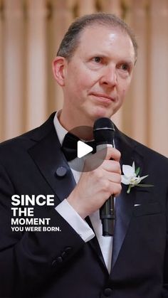 a man in a tuxedo holding a microphone