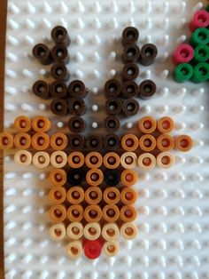 an animal made out of legos sitting on top of a white board covered in lots of different colored circles