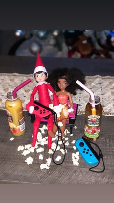 two elf dolls sitting on top of a table next to bottles and toothbrushes