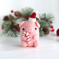 a small pink pig with a candy cane