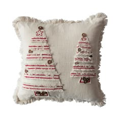 a white pillow with red and white christmas trees on the front, and buttons in the back