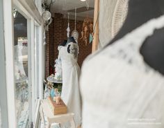 a dress shop with mannequins in the window and other items on display