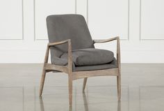 a grey chair with a gray cushion on it's back and arm rests against a white wall