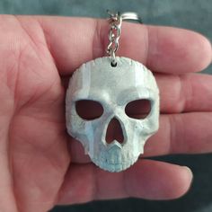 a hand holding a skull shaped key chain