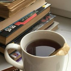 a cup of coffee sitting on top of a table next to books