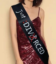 a woman wearing a red sequinned dress with a black sash that says just married