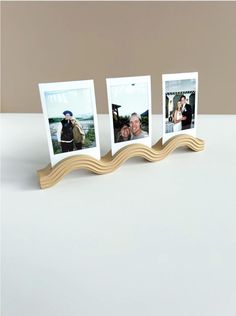 three photos are placed on a wooden stand