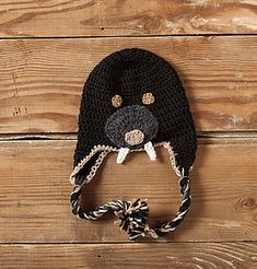 a crocheted hat with a bear face on the side and a knot around the brim